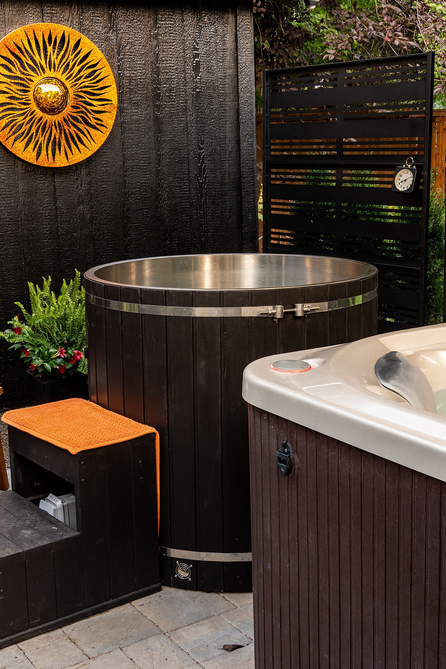 dark stained wooden lined cold plunge near hot tub in backyard