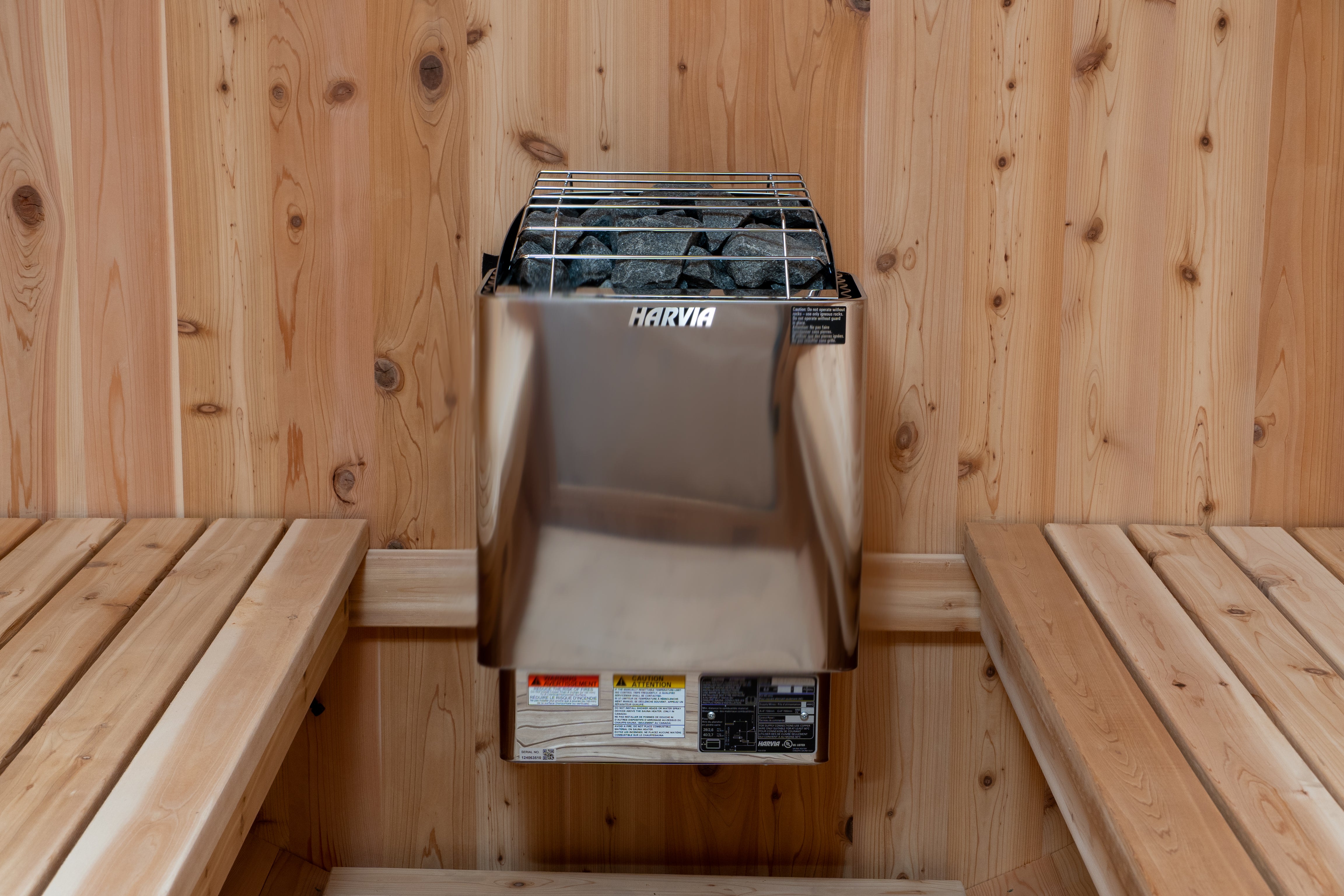 Harvia sauna heater installed in a wooden sauna with benches.